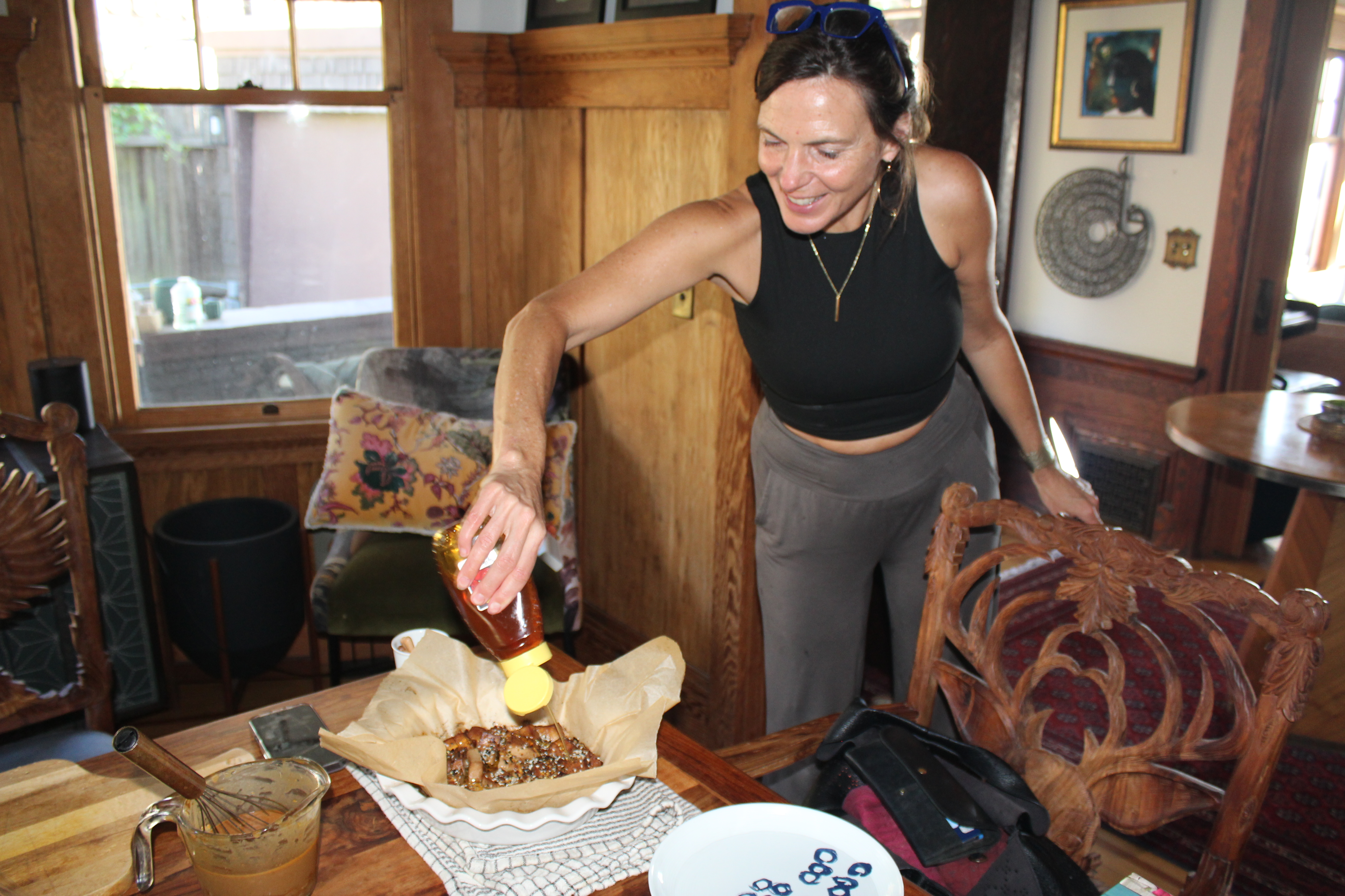 A founder pouring sacred honey over fresh food at a wooden table